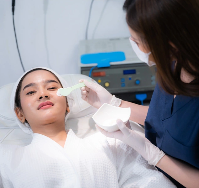 Image of a woman applying Glutathione Skin Whitening cream to face.