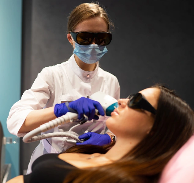 Woman undergoing laser treatment on her face.