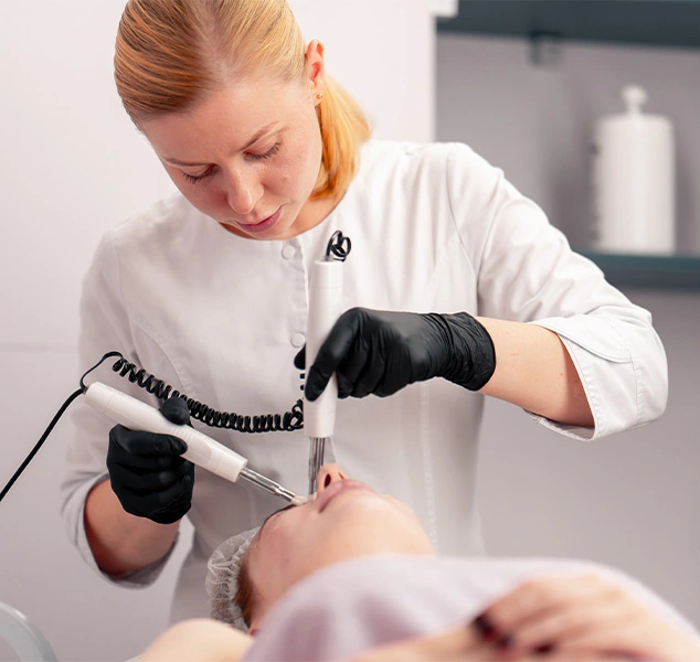 Woman receiving laser treatment on her face.